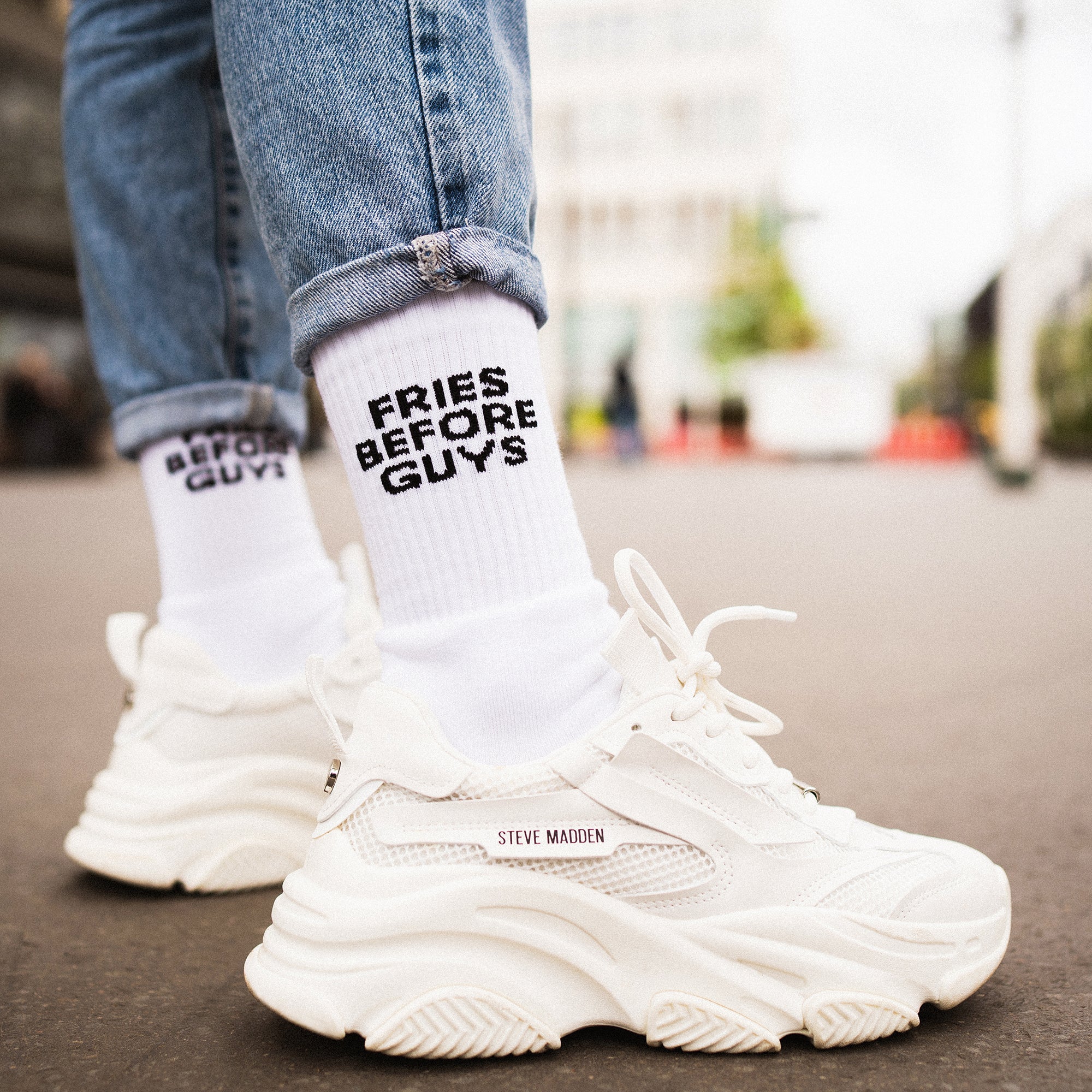 Weiße Tennis-Socken mit schwarzer Schrift „Fries Before Guys“ in Großbuchstaben.