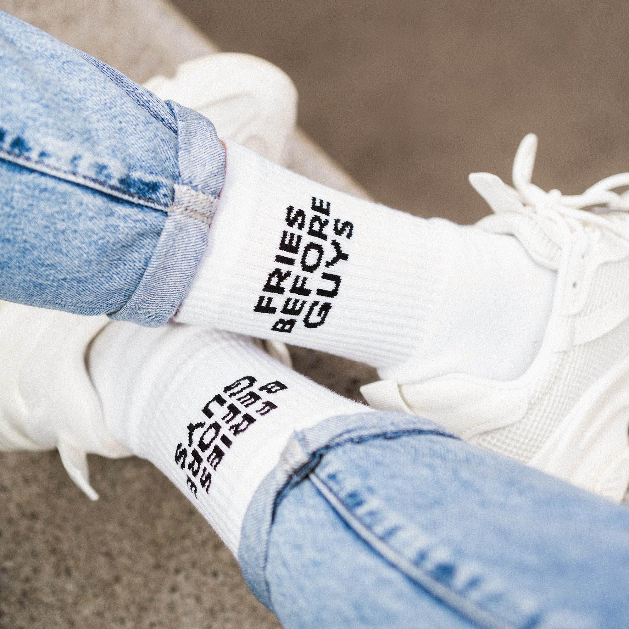 Weiße Sportsocken mit schwarzem "Fries Before Guys" Stick im Schneidersitz