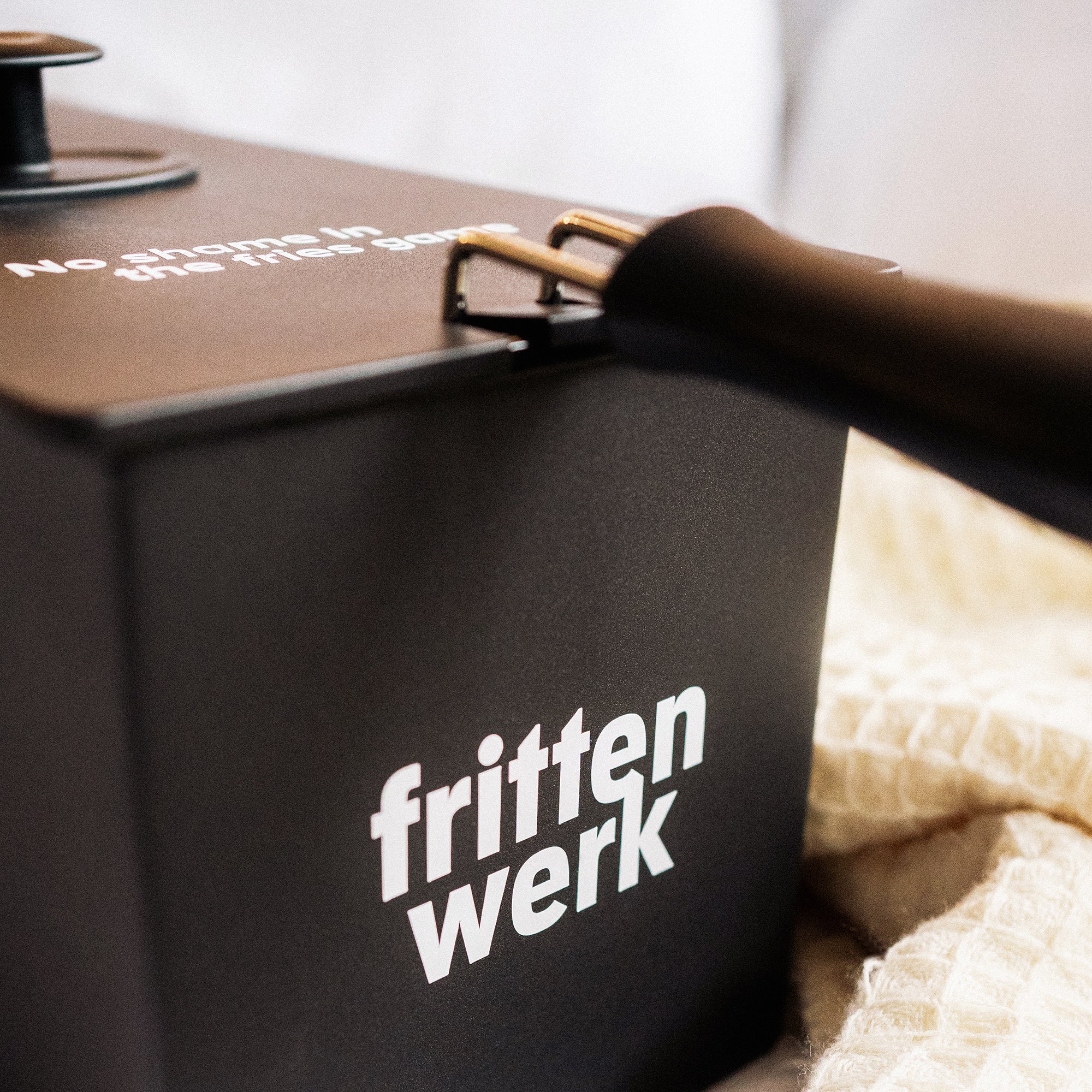 Nahaufnahme von weißem "frittenwerk"-Druck auf schwarzer Fritteuse