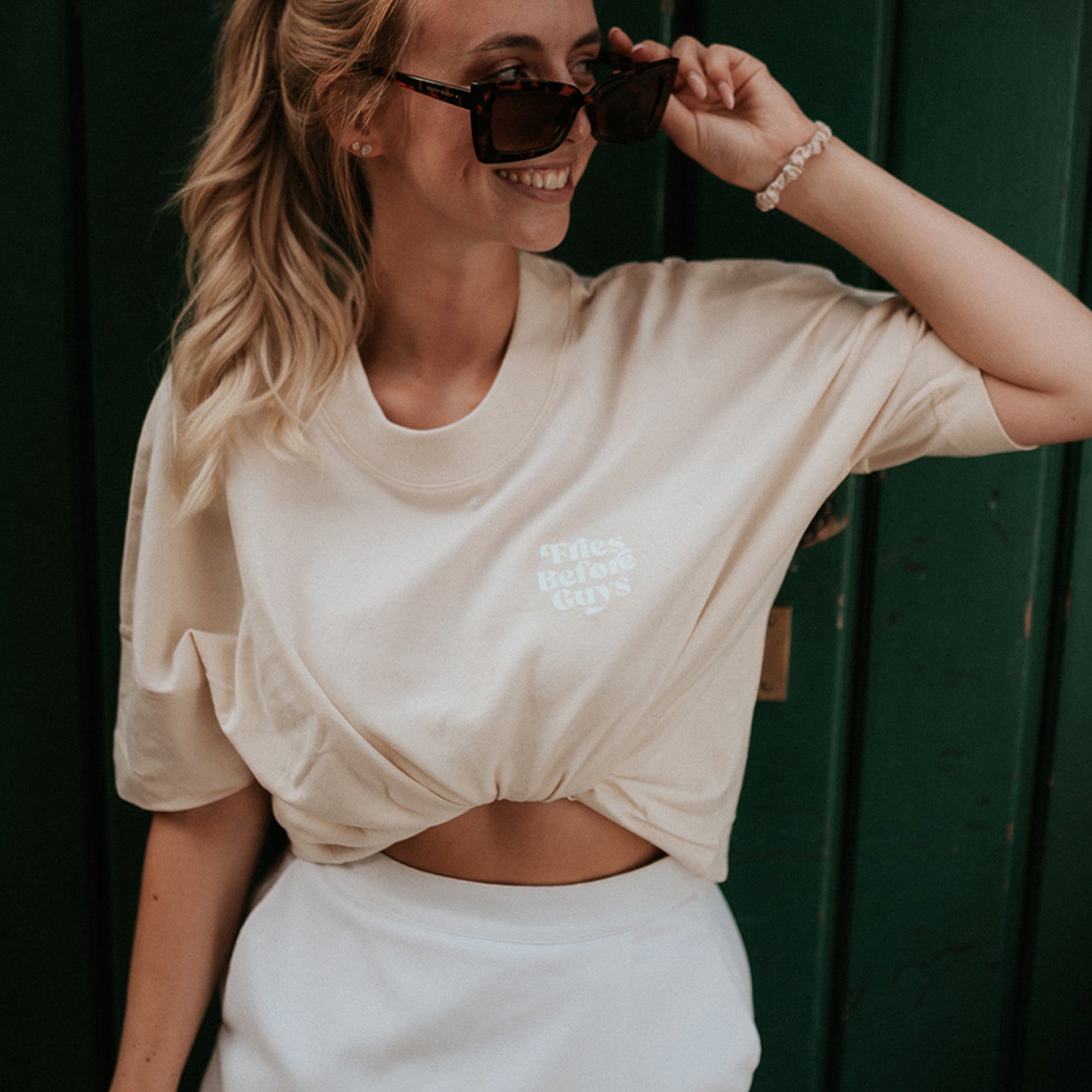 Frau trägt vanillafarbenes T-Shirt mit kleinem "Fries Before Guys"-Druck auf der Vorderseite