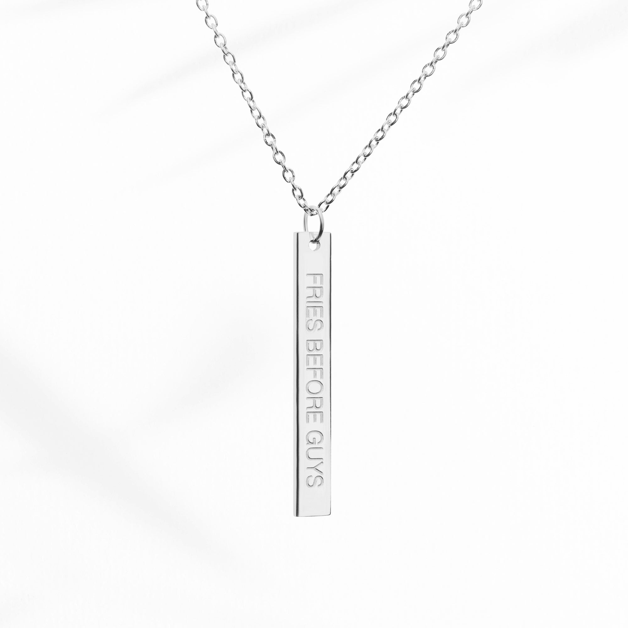 Silberne Kette mit länglichem Anhänger mit "Fries Before Guys"-Gravur auf der Vorderseite.