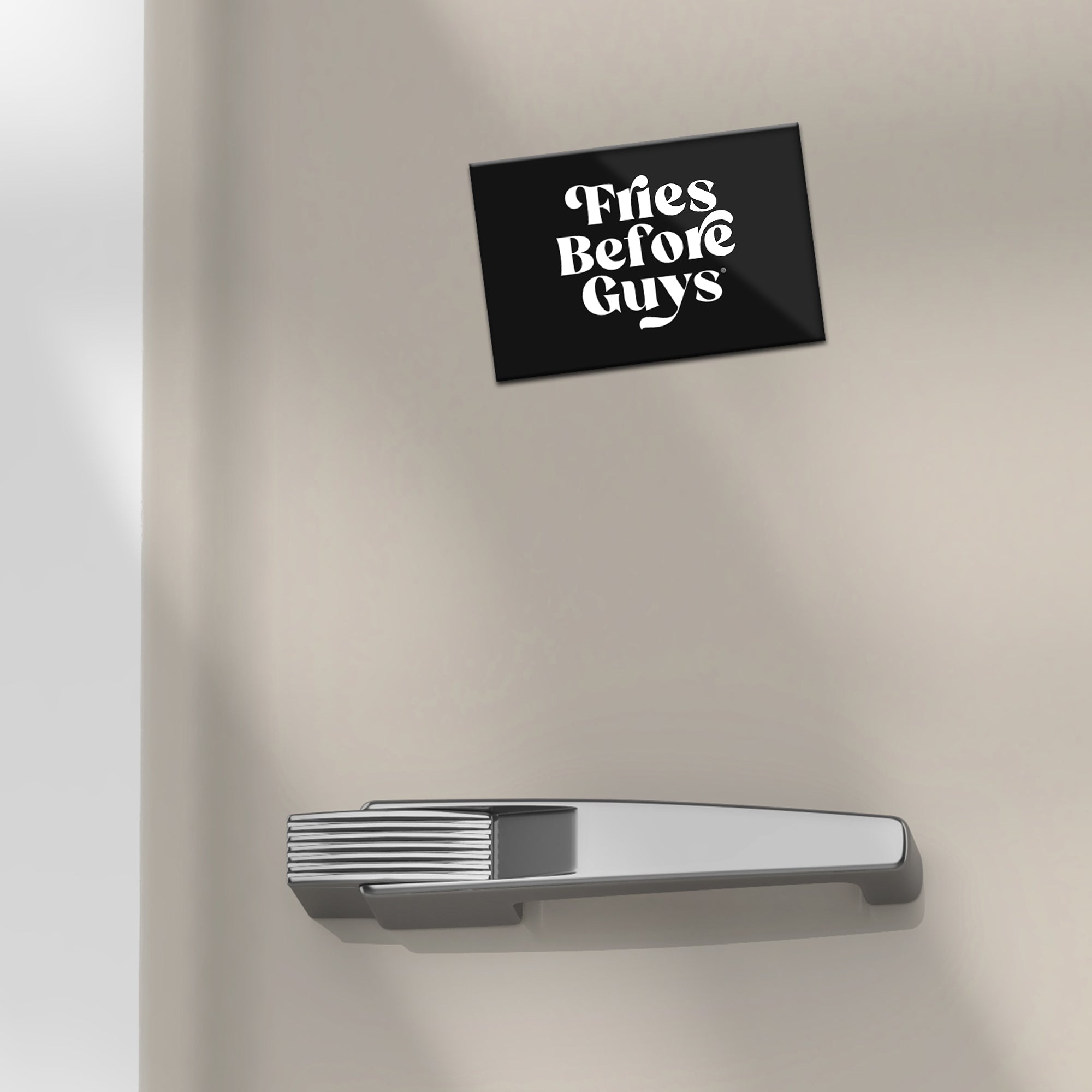Schwarzer Kühlschrankmagnet mit "Fries Before Guys"-Text auf Kühlschrank.