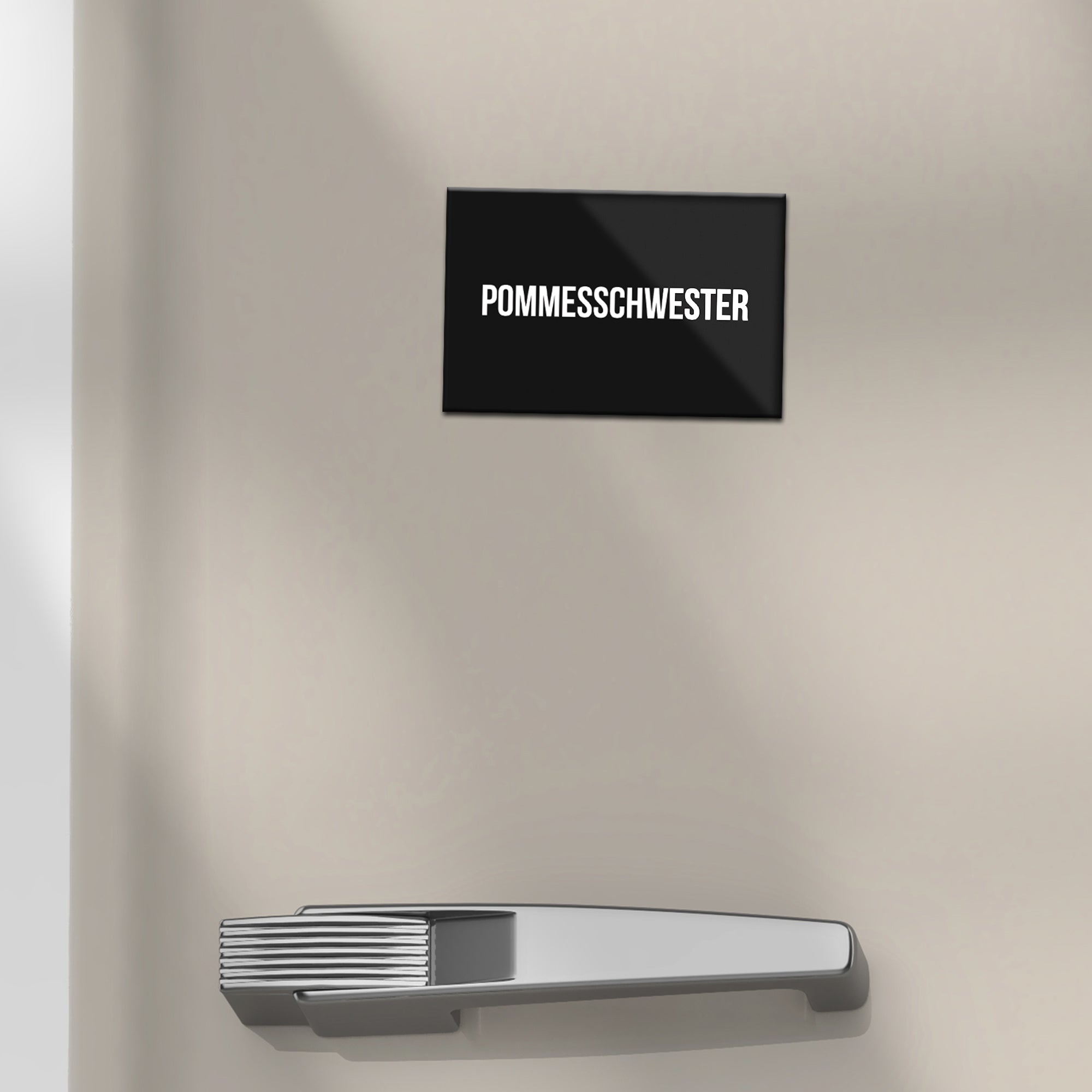 Schwarzer Kühlschrankmagnet "Pommesschwester"-Text auf Kühlschrank.