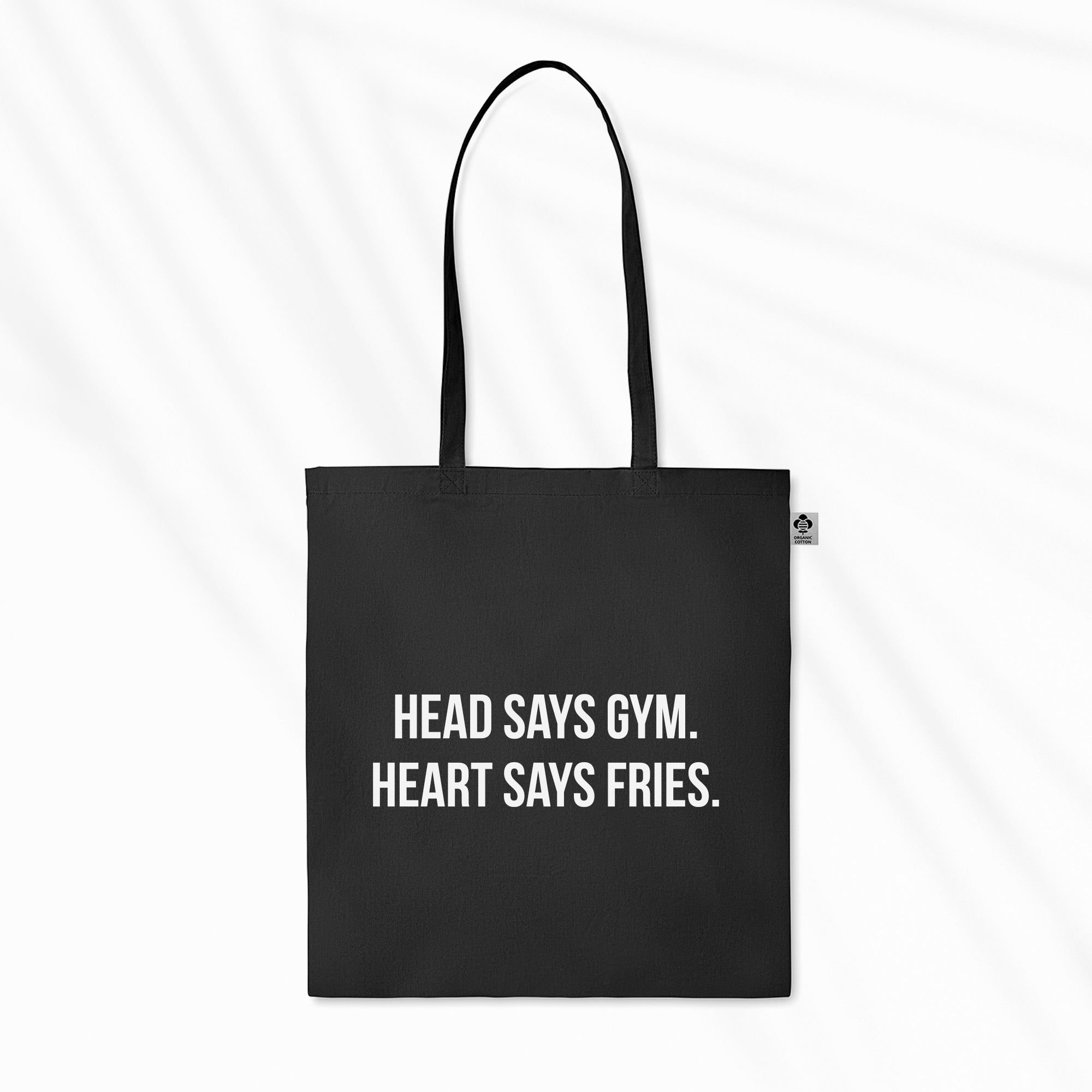 Produktbild einer schwarzen Tragetasche mit weißem "Head Says Gym. Heart Says Fries."-Druck