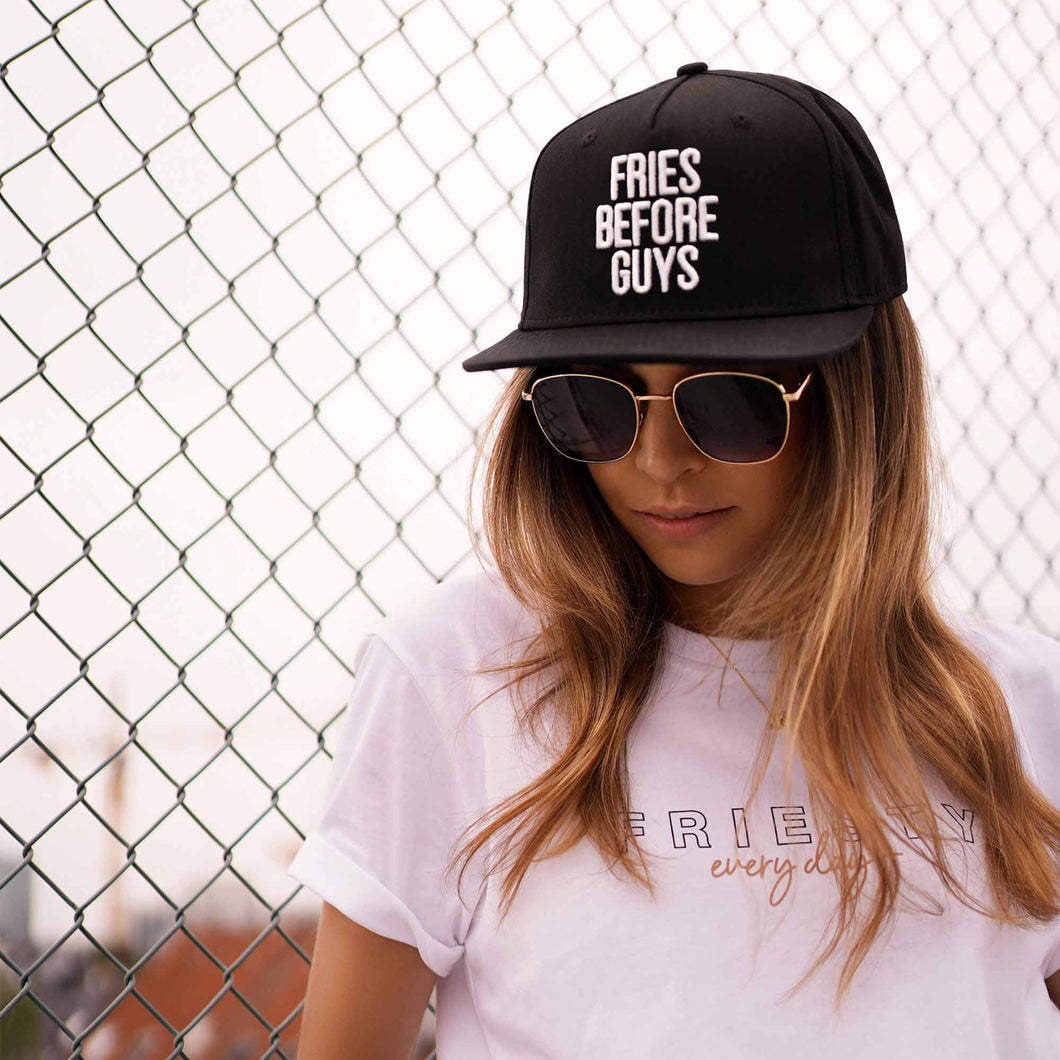 Junge Frau trägt schwarze Snapback mit weißer Stickerei