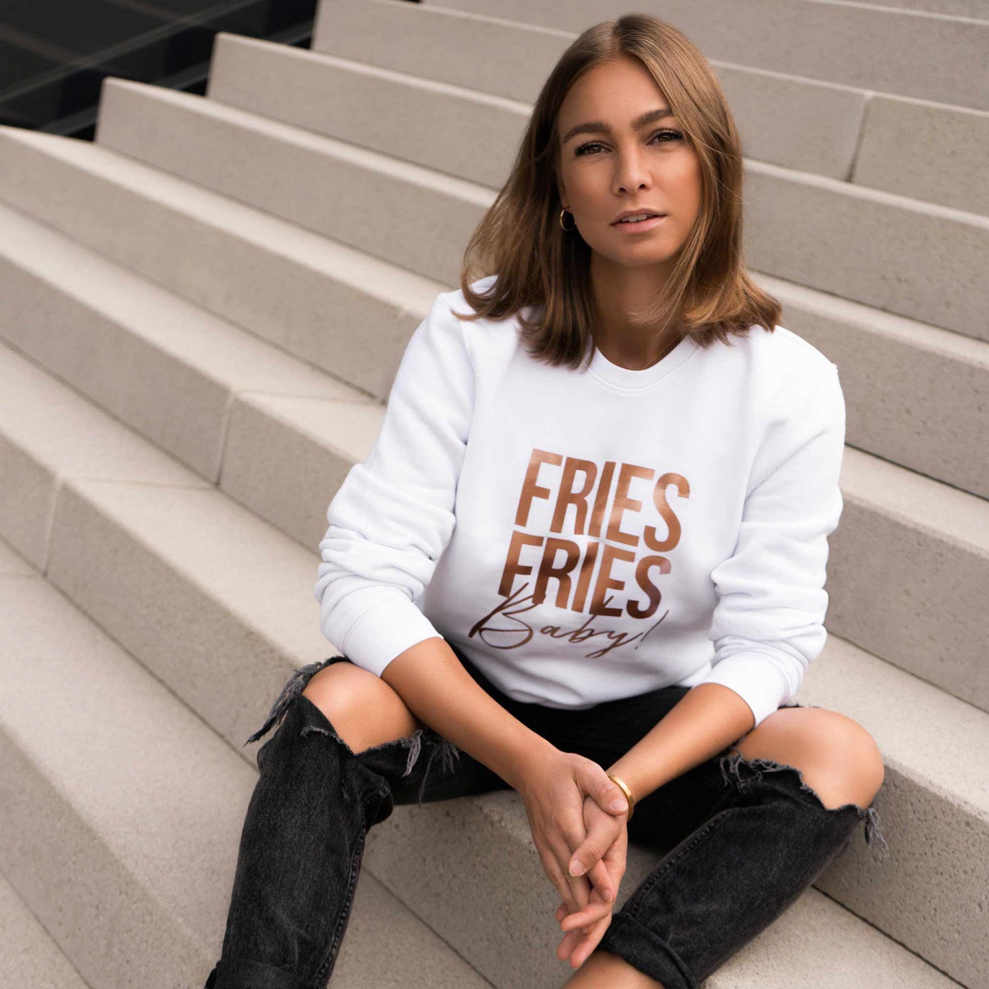Junge Frau sitzt in weißem Pullover